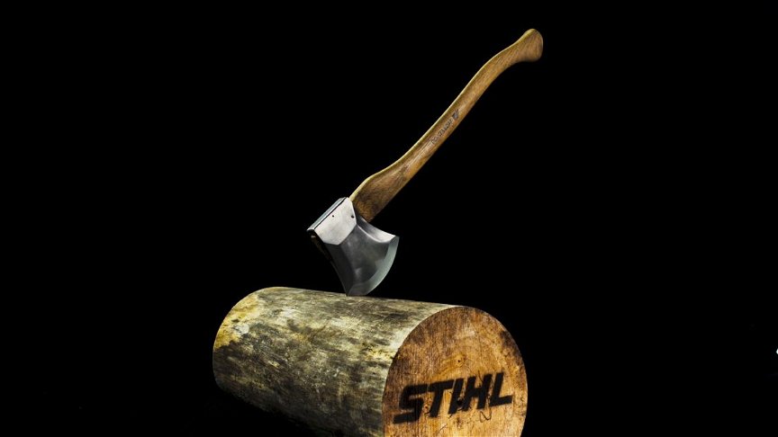 Eine STIHL Timbersports Wettkampfaxt steckt in einem Baumstamm