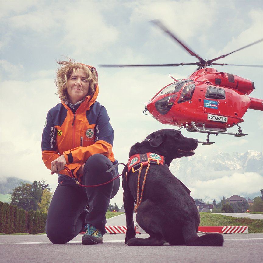 Bergretterin mit Hund und Helikopter